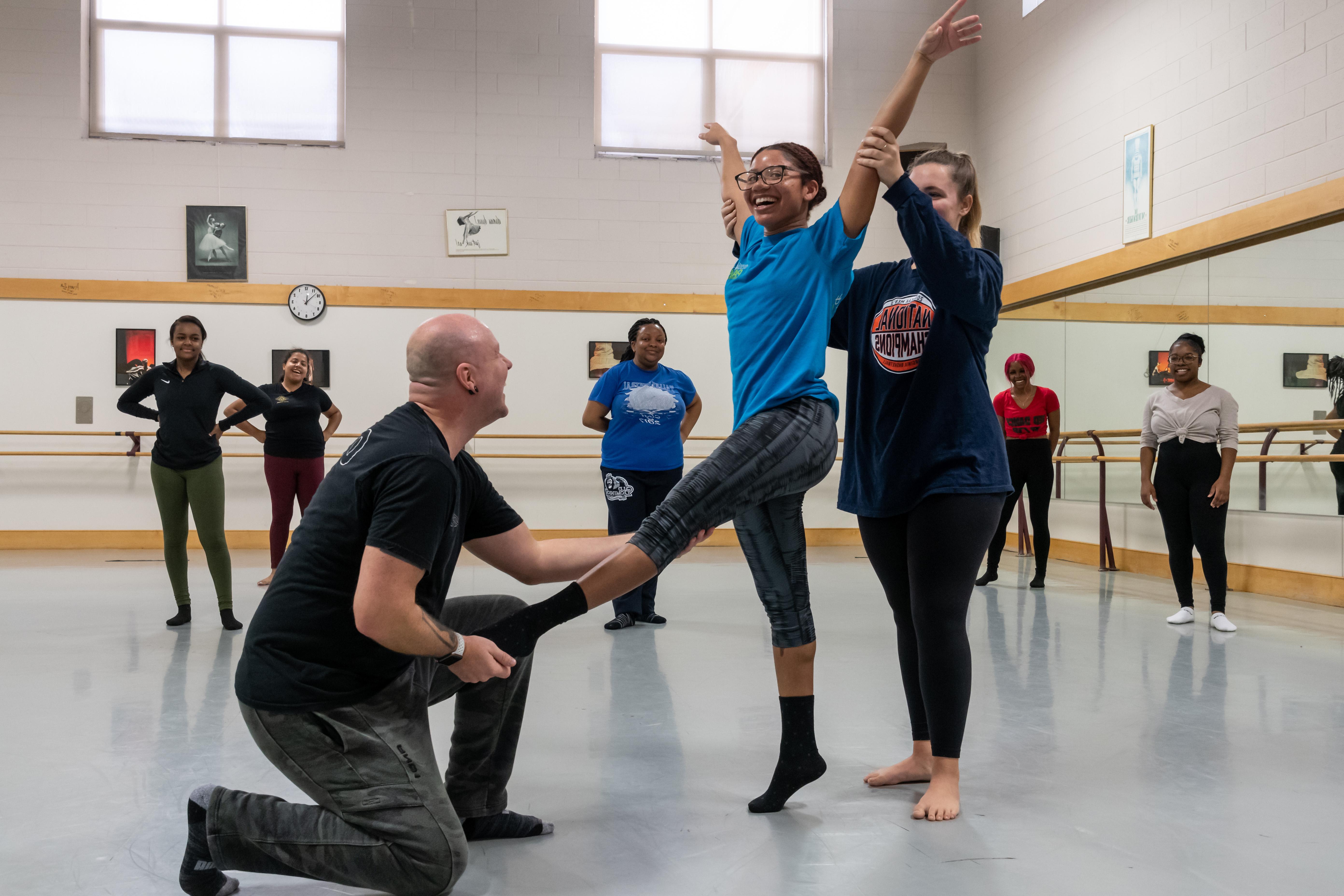 教练在大学预科暑期舞蹈强化课程中协助舞蹈学生.